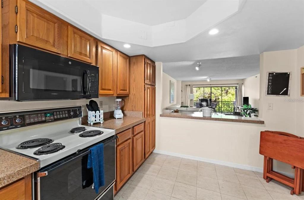1162 Carmel Circle, Unit 440 Casselberry, FL 32707 - Photo 13 of 30 a kitchen with stainless steel appliances granite countertop a sink stove and microwave
