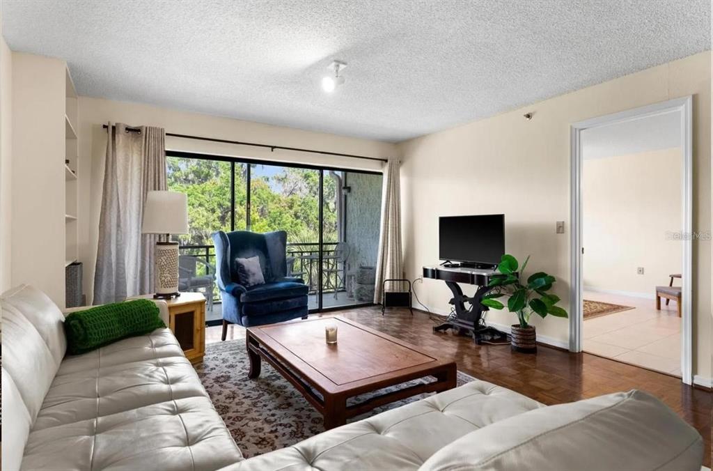 1162 Carmel Circle, Unit 440 Casselberry, FL 32707 - Photo 18 of 30 a living room with furniture a flat screen tv and a large window