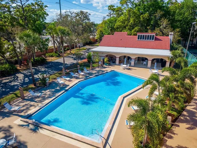 a view of a house with pool and chairs