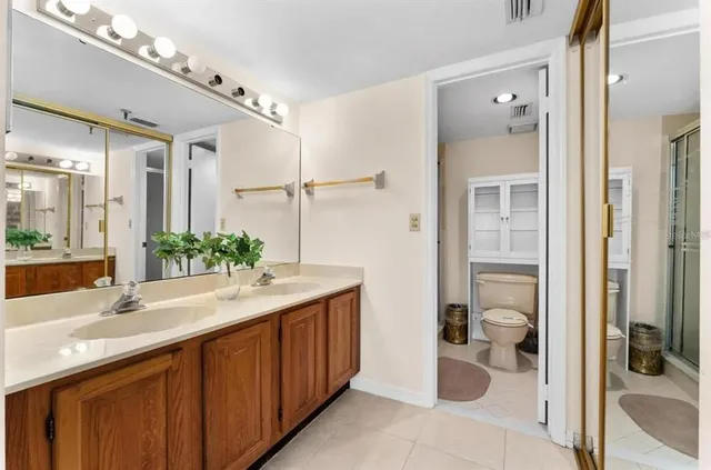 a bathroom with a sink and mirror with toilet