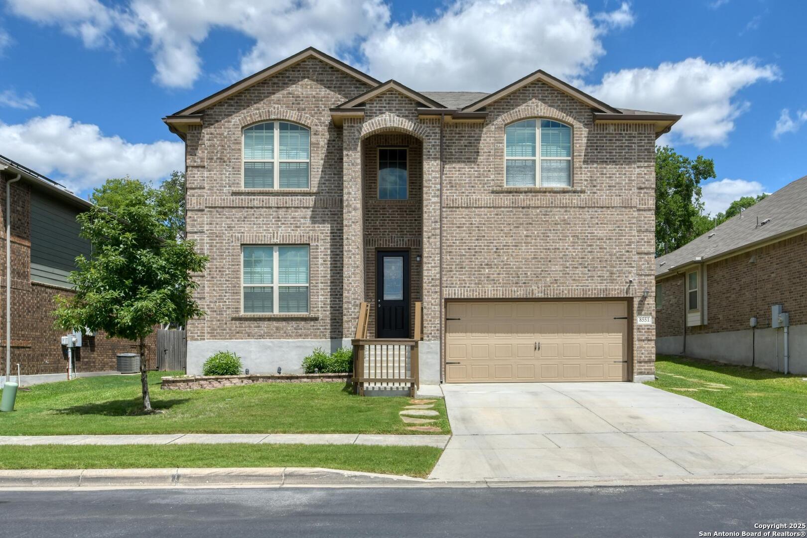 a front view of a house with a yard and garage