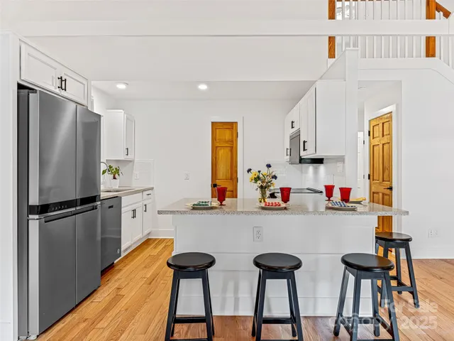 a kitchen with stainless steel appliances a refrigerator and a stove top oven