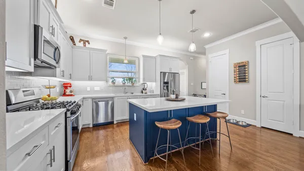 a kitchen with stainless steel appliances a kitchen island a stove a table and chairs in it