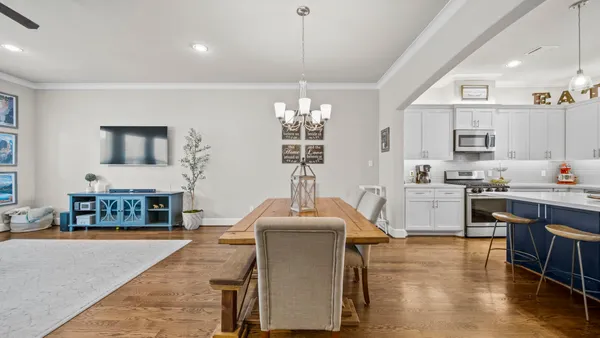 a kitchen with a dining table chairs sink and stove