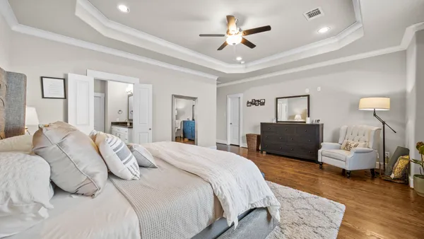 a bedroom with a large bed and a chandelier