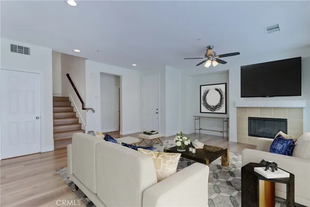 a living room with furniture a flat screen tv and a fireplace