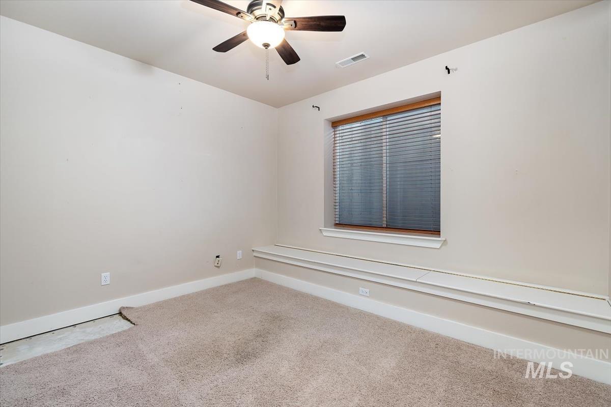 10462 West Lanktree Gulch Road Star, ID 83669 - Photo 36 of 48 Carpeted room featuring a ceiling fan, a window with wood-finish trim, and white baseboards