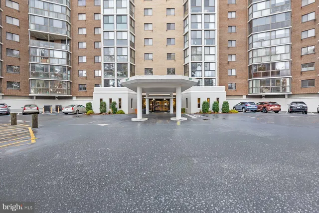 a view of a white house with potted plants