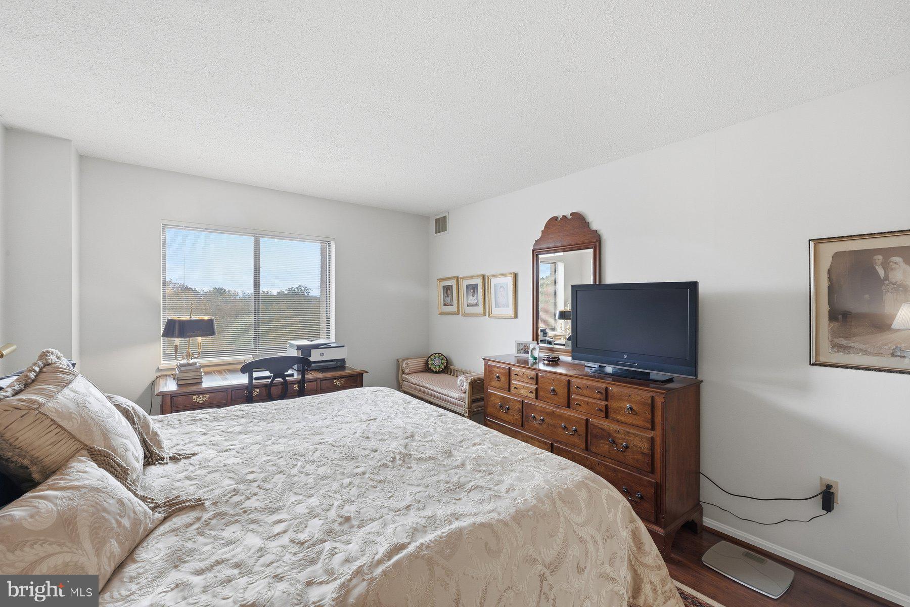 15107 Interlachen Drive, Unit 2822 Silver Spring, MD 20906 - Photo 24 of 35 a bedroom with a bed and a flat screen tv