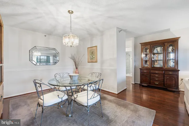 a dining room with furniture a chandelier and wooden floor