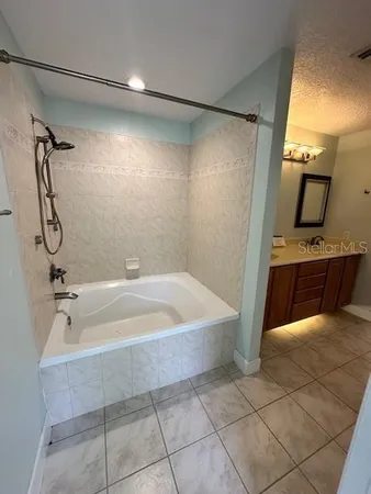 a spacious bathroom with a bathtub and shower