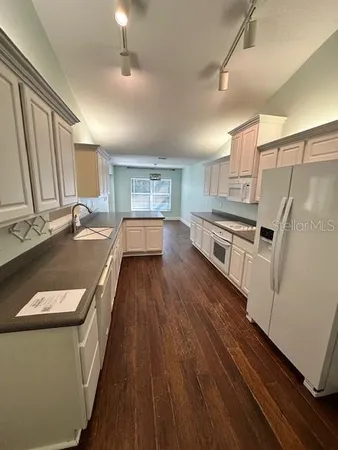 a kitchen with granite countertop a sink a counter space stainless steel appliances and cabinets