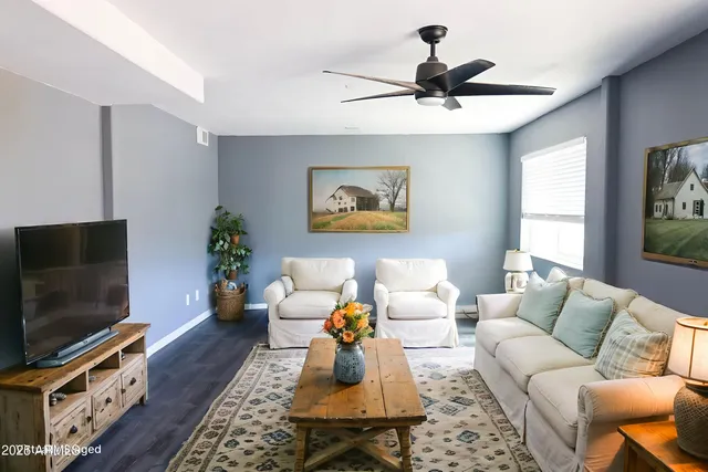 a view of a livingroom with a ceiling fan and window