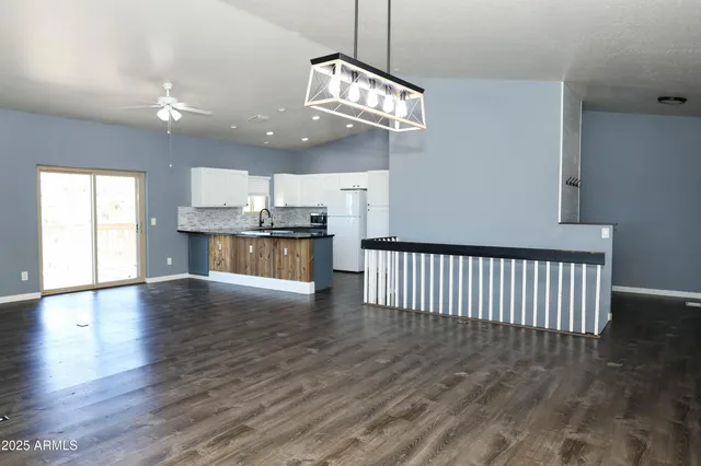 a kitchen with stainless steel appliances granite countertop a refrigerator a sink and white cabinets
