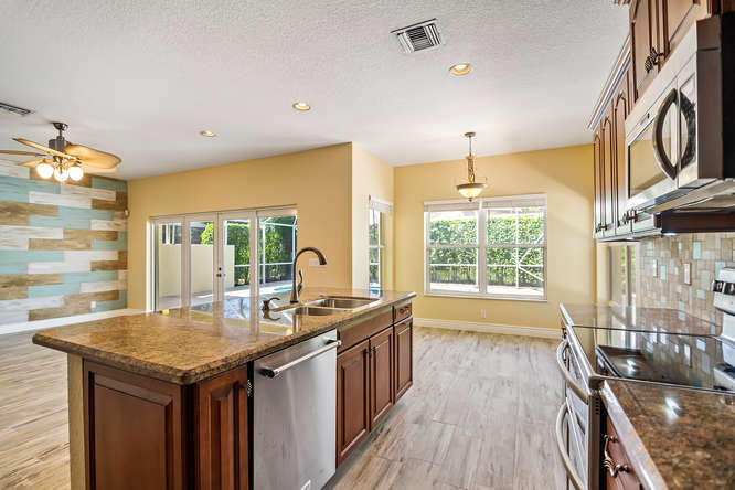 20933 La Plata Court Boca Raton, FL 33428 - Photo 14 of 60 a kitchen with granite countertop a sink and a stove