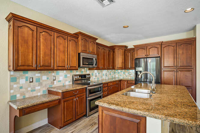 20933 La Plata Court Boca Raton, FL 33428 - Photo 16 of 60 a kitchen with stainless steel appliances granite countertop a sink microwave stove refrigerator and cabinets