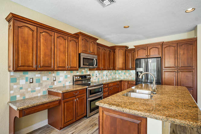 20933 La Plata Court Boca Raton, FL 33428 - Photo 17 of 60 a kitchen with stainless steel appliances granite countertop a sink microwave stove refrigerator and cabinets