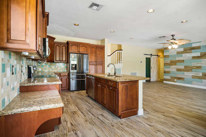 20933 La Plata Court Boca Raton, FL 33428 - Photo 18 of 60 a large kitchen with stainless steel appliances wooden floor and a large window