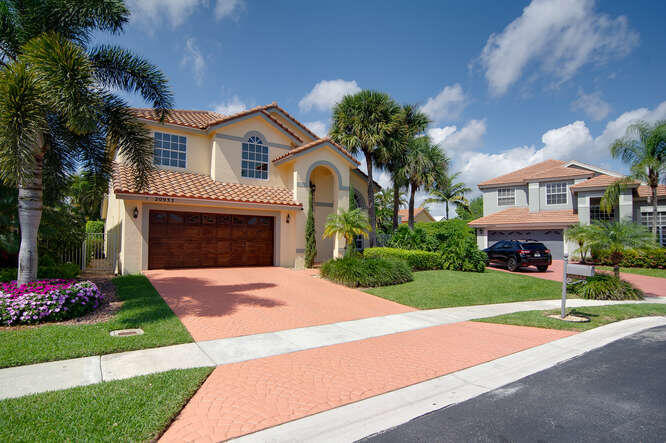 20933 La Plata Court Boca Raton, FL 33428 - Photo 3 of 60 a front view of a house with a garden and yard