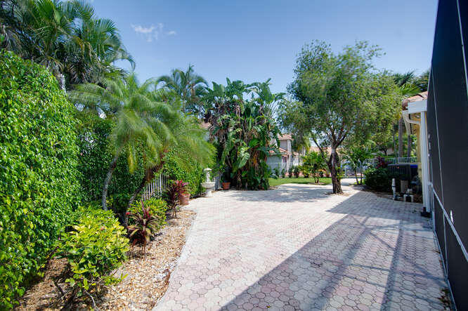 20933 La Plata Court Boca Raton, FL 33428 - Photo 36 of 60 a view of a street with potted plants and large trees