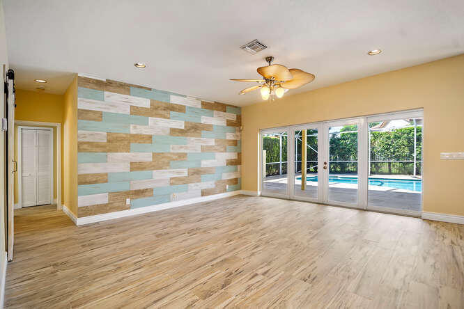 20933 La Plata Court Boca Raton, FL 33428 - Photo 8 of 60 a view of an empty room with a window and wooden floor