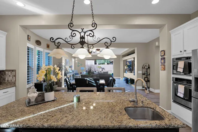 a large kitchen with a counter space a sink appliances and living room view