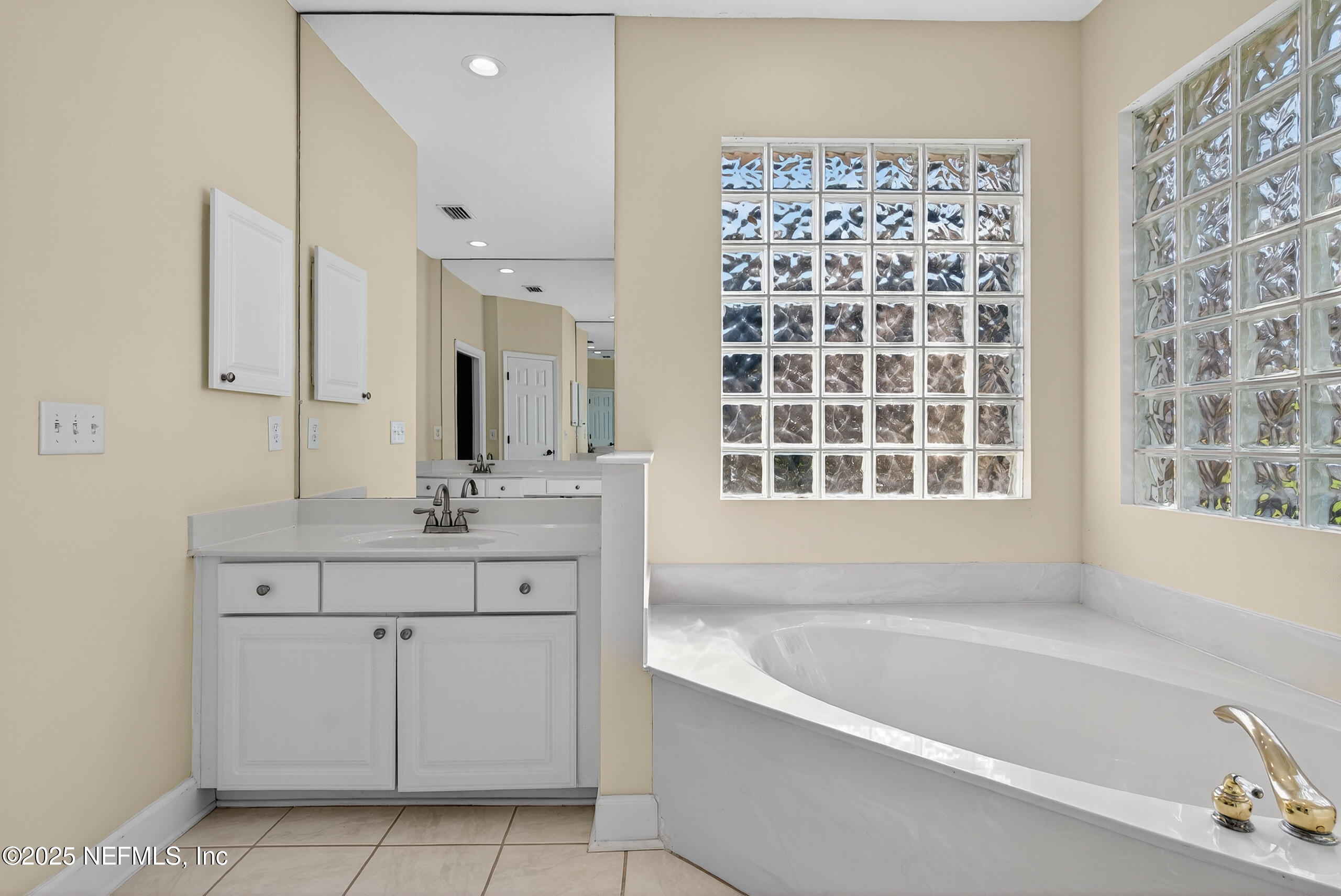 577 Hunters Grove Court Orange Park, FL 32073 - Photo 26 of 40 a bathroom with a bathtub a sink a window and a shower