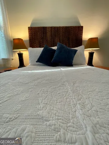 a bedroom with a bed dresser and a window