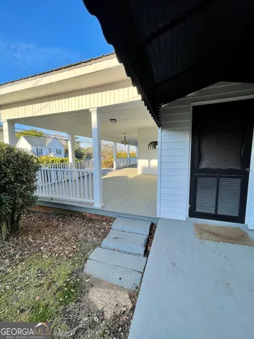 a view of a porch with a floor to ceiling window and stairs