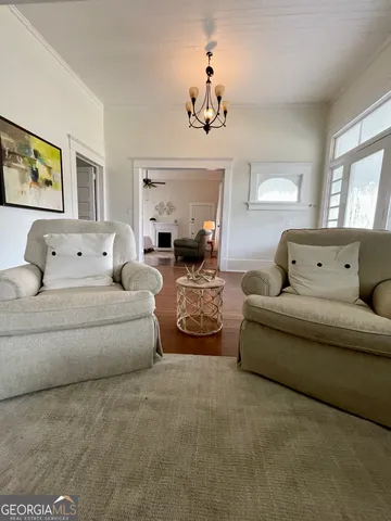 a living room with furniture and a chandelier