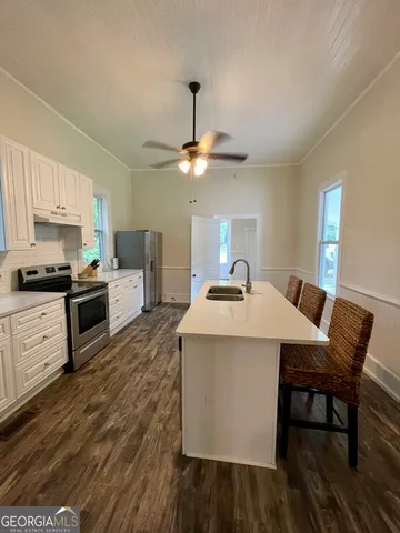 a kitchen with a table chairs stove and cabinets