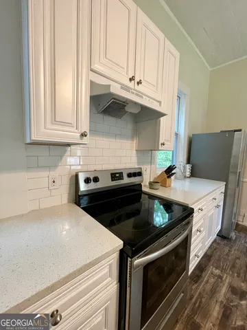a kitchen with stainless steel appliances granite countertop a stove a sink and a microwave