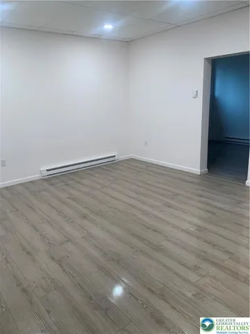 a view of an empty room with wooden floor