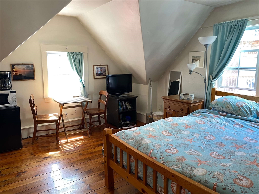 8 May Street Beverly, MA 01915 - Photo 12 of 25 a bedroom with a bed a chair and computer on the table
