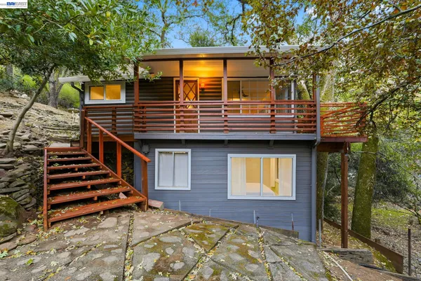 a view of a house with wooden deck and furniture