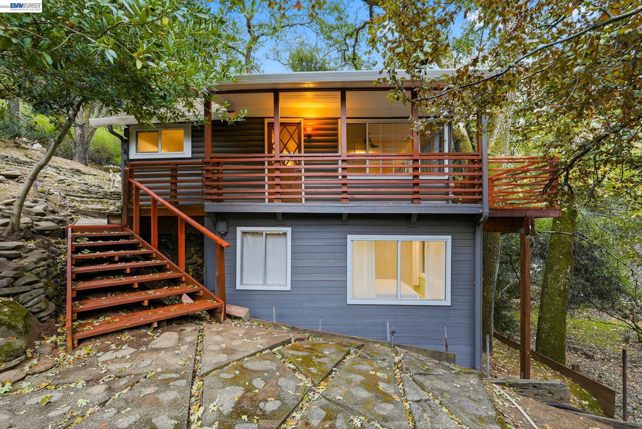 a view of a house with wooden deck and furniture