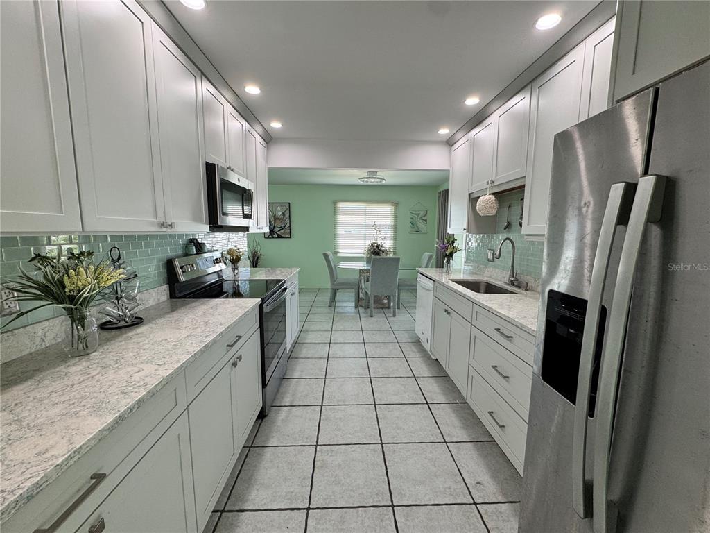 1048 Porpoise Road Venice, FL 34293 - Photo 4 of 26 a large kitchen with stainless steel appliances a sink a counter top space cabinets and a counter top space