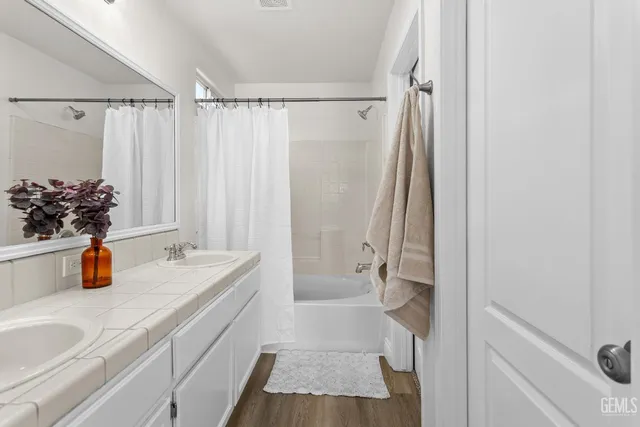 a bathroom with a tub sink and mirror