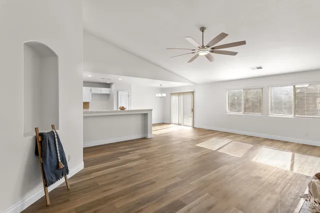 a view of an empty room with a window and wooden floor