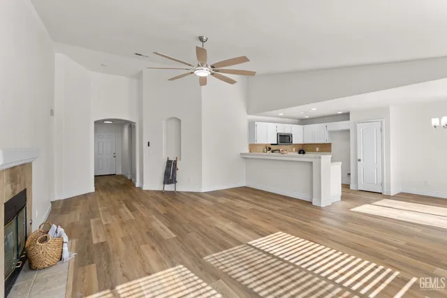 a view of a kitchen with wooden floor and a ceiling fan