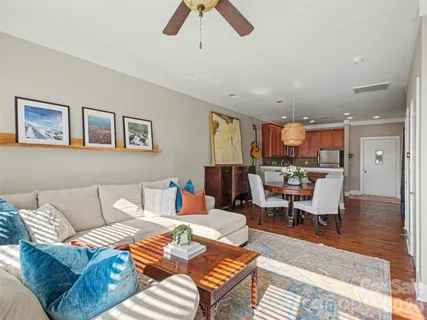 a living room with furniture kitchen view and a window