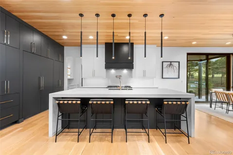 a kitchen with stainless steel appliances granite countertop white cabinets and a window