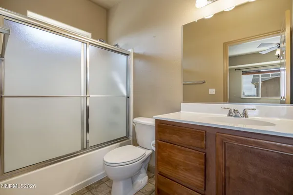 a bathroom with a granite countertop sink mirror vanity and toilet