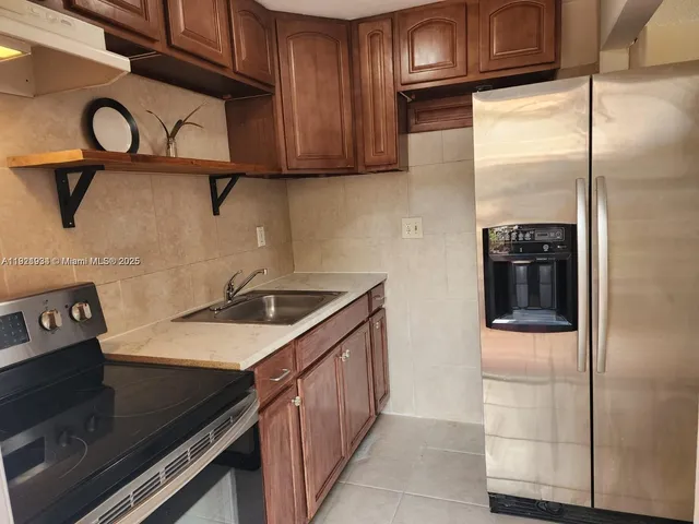 a kitchen with stainless steel appliances granite countertop a refrigerator and a stove