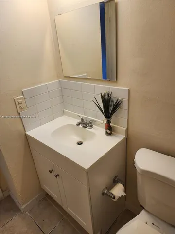 a bathroom with a sink mirror and toilet