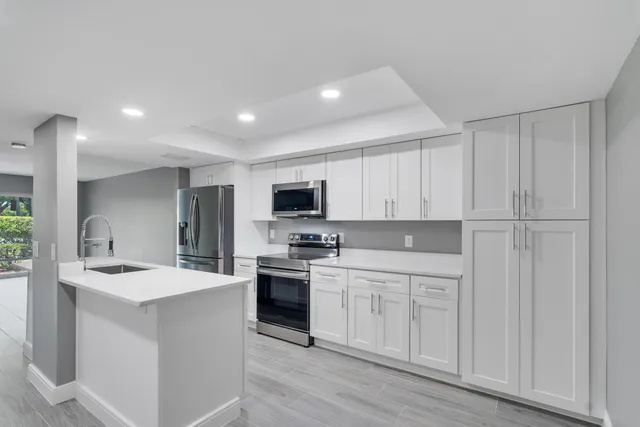 a kitchen with white cabinets sink and stainless steel appliances