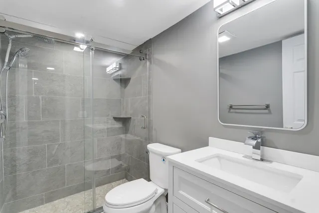 a bathroom with a sink a toilet and shower