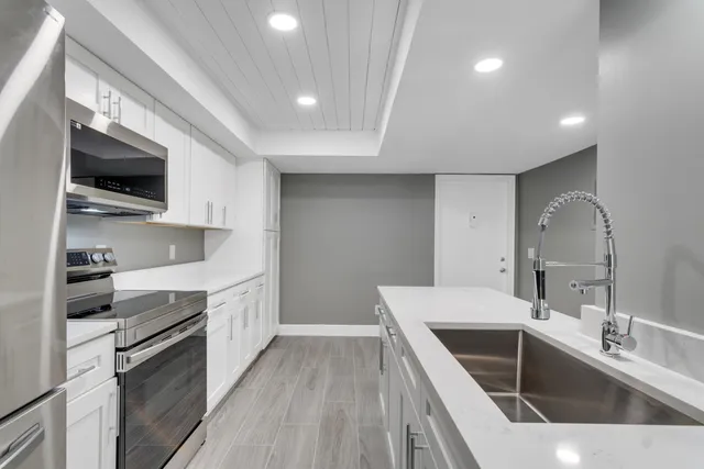 a kitchen with a sink stainless steel appliances and cabinets