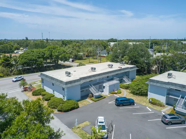 an aerial view of a house with a garden and lake view