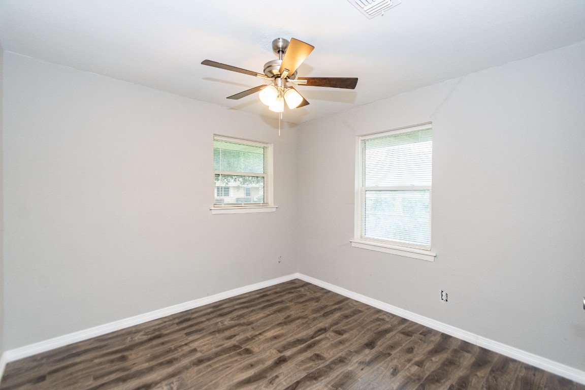 2002 Nottingham Street Pasadena, TX 77502 - Photo 16 of 33 an empty room with wooden floor chandelier fan and windows